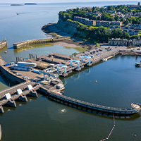 people enjoying a meal with sandwiches and beverages on a wooden table casual dining experience with friends sharing three types of food