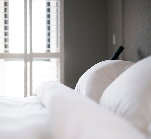 three story building with stone exterior featuring Health Plus Pharmacy signage and multiple windows in a small town setting representing community health and wellness six essential services